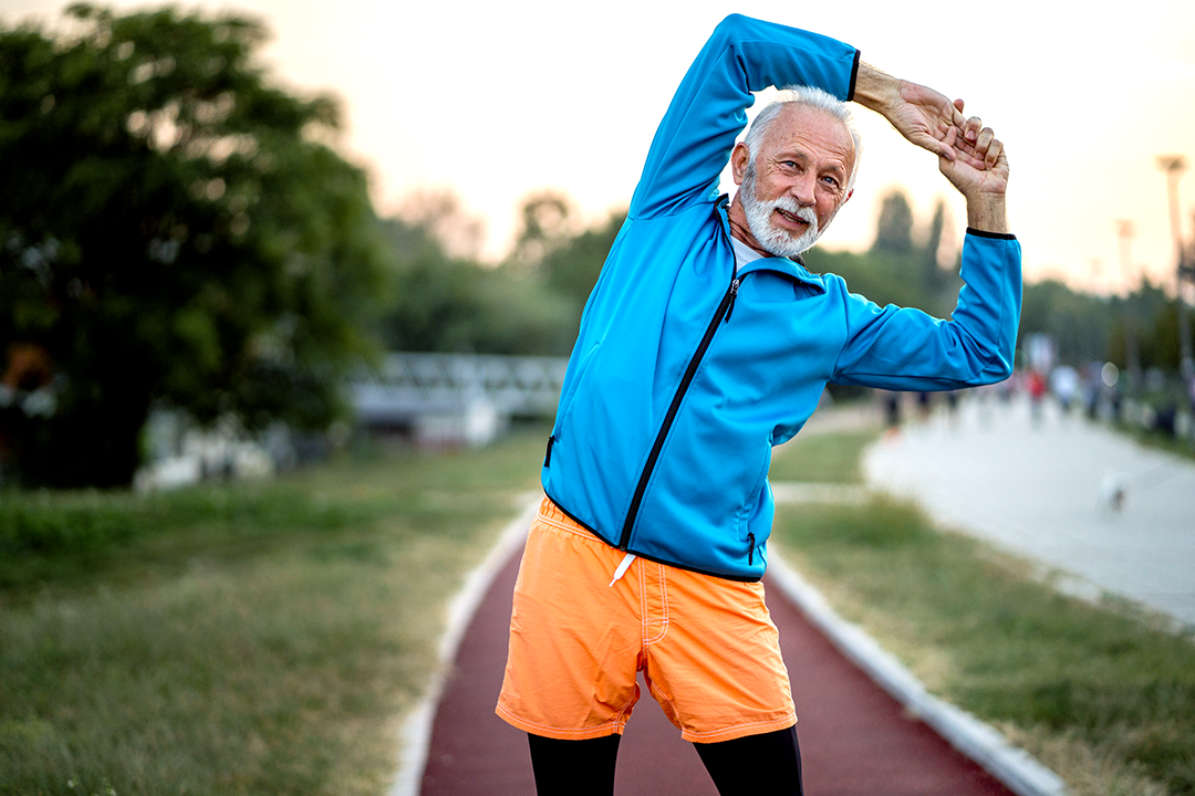 Older man stretching outdoors.