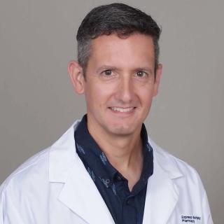 Registered pharmacist Brandon Fahs smiles in his Express Scripts Pharmacy lab coat.